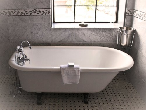 A vintage-style bathtub with a towel, set in a stylish bathroom with marble walls and a window.