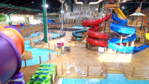 Indoor water park featuring colorful water slides, lazy river, and lounging areas. Bright and spacious atmosphere.