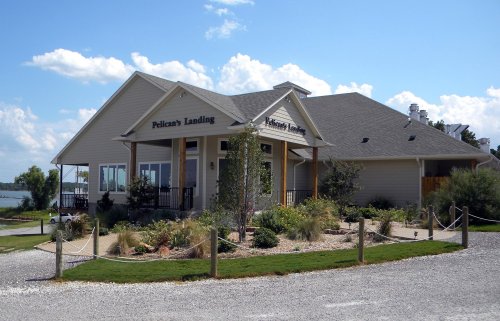 A charming building with a sign reading "Felicia's Landing," surrounded by greenery and a gravel pathway.