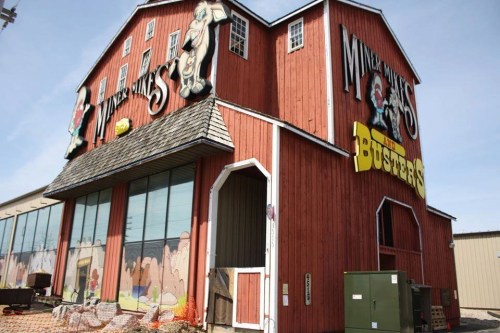 A large, colorful barn-style building with cartoon characters and signage for "Miner Mike's" and "Buster's."