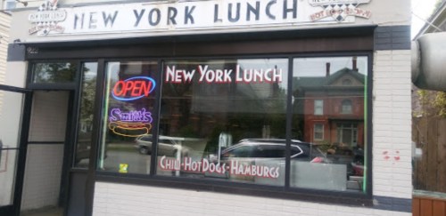 Exterior of New York Lunch restaurant with an "OPEN" sign and menu items displayed in the window.