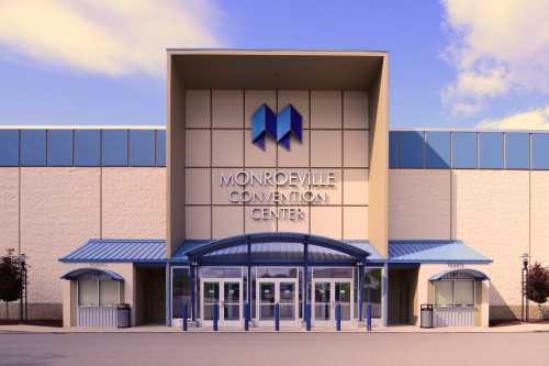 Exterior view of the Monroeville Convention Center, featuring a modern entrance and blue accents against a clear sky.