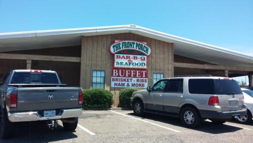 Exterior of "The Front Porch" restaurant featuring a buffet sign, with two parked vehicles in front.