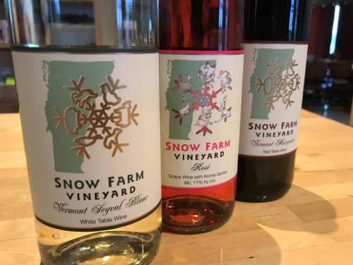 Three bottles of wine from Snow Farm Vineyard, featuring distinct labels for white, rosé, and red varieties.