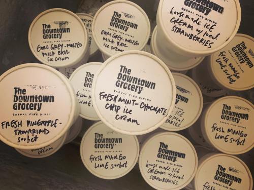 Containers of ice cream and sorbet labeled with flavors like fresh pineapple, mint chocolate chip, and mango lime.