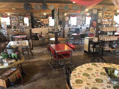 Cozy café interior with vintage decor, tables, and a coffee display, creating a warm and inviting atmosphere.