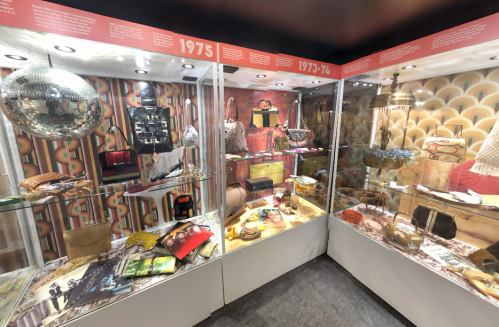 Display case featuring vintage fashion accessories and decor from the 1970s, including bags, jewelry, and decor items.