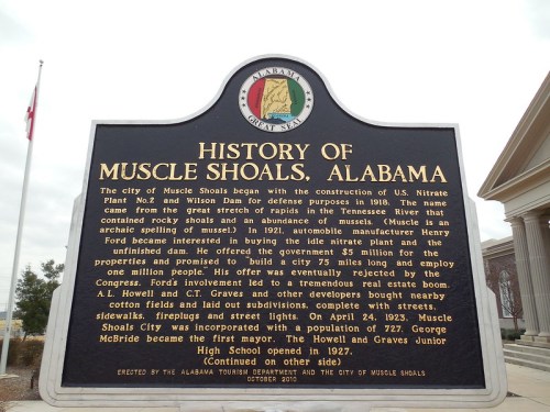 Historical plaque detailing the founding and development of Muscle Shoals, Alabama, including key figures and events.