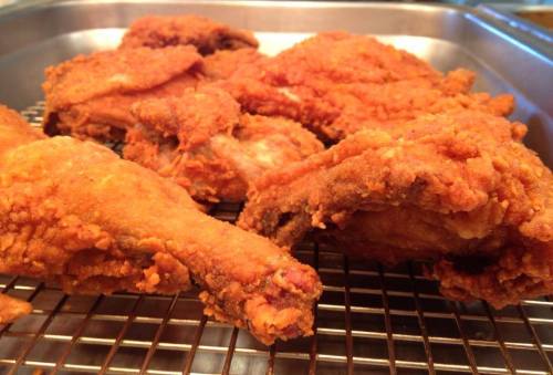 Crispy, golden-brown fried chicken pieces resting on a wire rack.