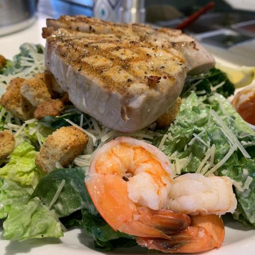 Grilled tuna steak atop a bed of romaine lettuce, croutons, shrimp, and sprinkled with Parmesan cheese.