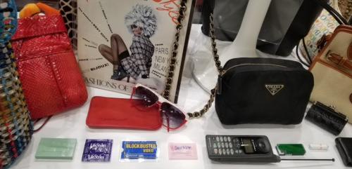 A display of vintage items including handbags, sunglasses, and old membership cards, showcasing retro fashion and nostalgia.