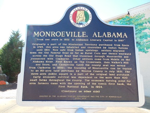 Sign about Monroeville, Alabama, detailing its history and significance, including early settlement and local development.