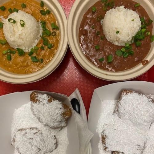 Two bowls of rice with sauces and a plate of powdered sugar-covered beignets.