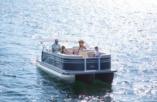 A family enjoys a sunny day on a pontoon boat gliding over sparkling water.