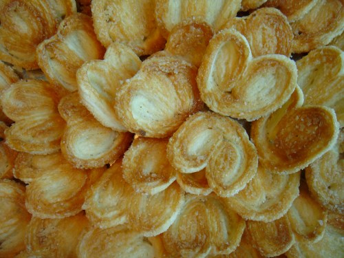 A close-up of golden-brown palmiers arranged in a decorative pattern, showcasing their flaky texture.