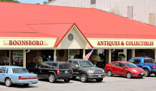 A building with a red roof labeled "Boonsboro Antiques & Collectibles," featuring parked cars in front.