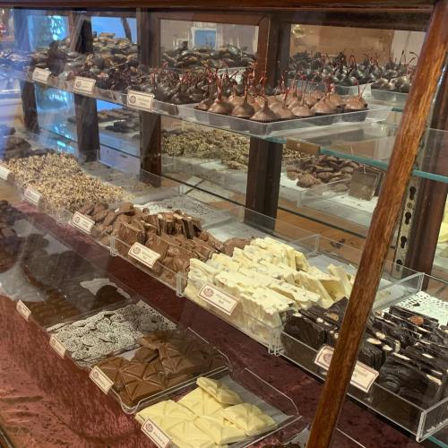 A display case filled with various types of chocolates and confections, including truffles and bars.