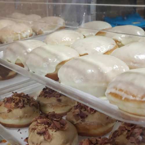 A display of assorted donuts, including glazed and ones topped with chocolate and nuts.