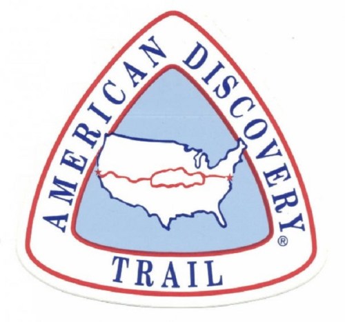 Logo of the American Discovery Trail featuring a map of the U.S. with a red trail line and blue background.