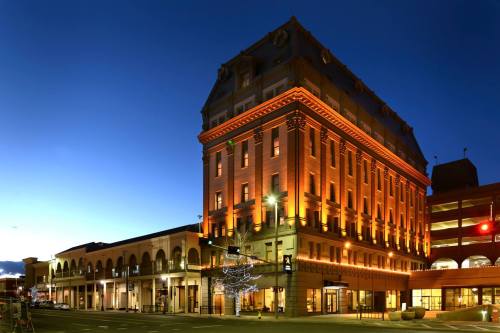 Historic building illuminated at dusk, showcasing architectural details and a vibrant sky.