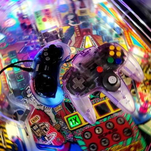 Two video game controllers on a colorful arcade machine, showcasing retro gaming elements and vibrant artwork.