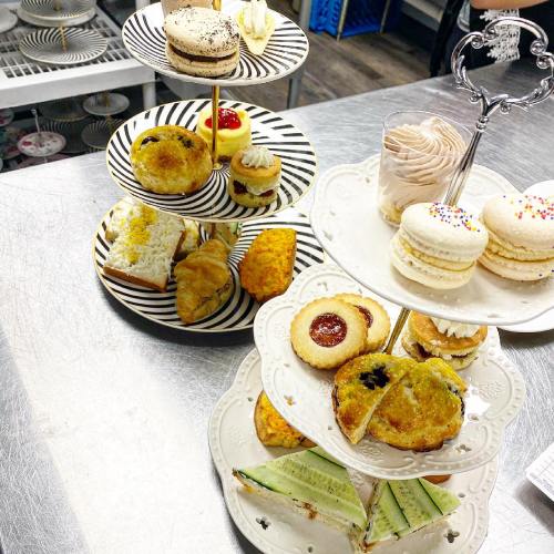 A tiered stand filled with assorted pastries, including macarons, cupcakes, cookies, and savory treats.