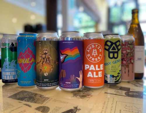 A variety of colorful beer cans displayed on a table, featuring unique designs and labels.