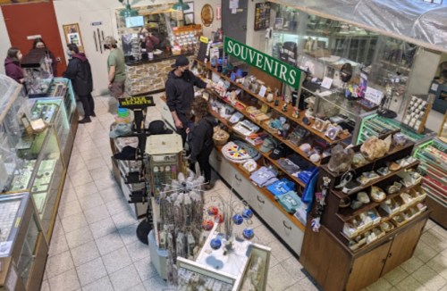 Aerial view of a bustling souvenir shop with various items for sale and customers browsing.
