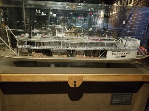 Model of the steamboat Bertrand displayed in a glass case, showcasing its detailed structure and cargo.