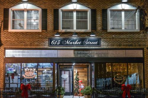 A brick storefront with festive decorations, featuring a sign that reads "6/3 Market Street" and a snowman display.