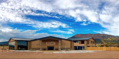 Exterior view of the Dinosaur Discovery Museum, featuring a modern building against a backdrop of mountains and blue sky.