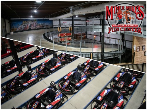 Aerial view of go-karts lined up at Miner Mike's Indoor Family Fun Center, featuring a curved racetrack in the background.