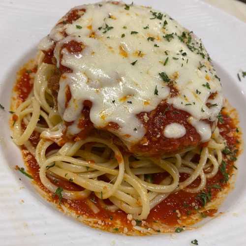 A plate of spaghetti topped with marinara sauce and melted cheese, garnished with parsley.