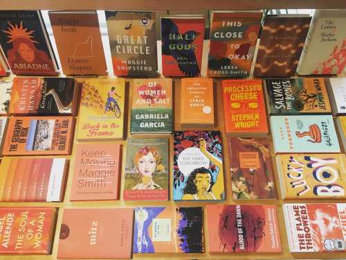 A colorful display of various book covers arranged on a table, featuring diverse titles and authors.