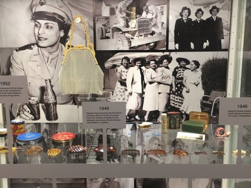 Display of vintage items and photographs showcasing women's fashion and history from the 1940s and 1950s.