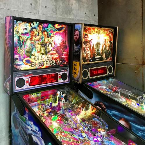 Two pinball machines: "Ghostbusters" on the left and "Game of Thrones" on the right, with colorful artwork and lights.