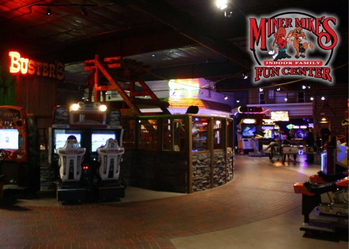 Interior of an arcade with various games and attractions, featuring bright lights and a fun atmosphere.