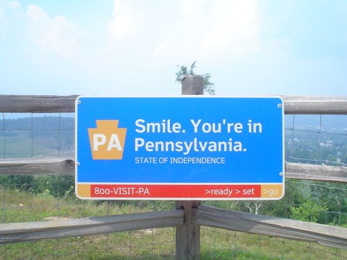 Sign welcoming visitors to Pennsylvania, featuring the state logo and the message: "Smile. You're in Pennsylvania."
