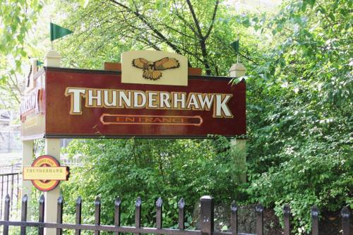 Sign for "Thunderhawk" entrance surrounded by greenery and trees.