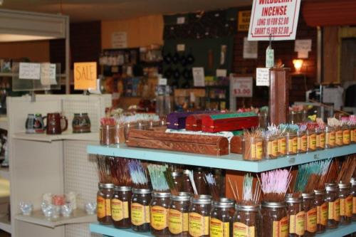 A colorful display of incense sticks and jars in a shop, with signs indicating sales and prices.
