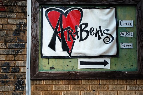 Sign for "Art Beats" featuring a heart design, with arrows pointing to coffee, music, and gifts.