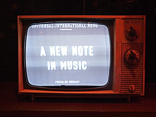 A vintage television displaying the text "A New Note in Music" on the screen.