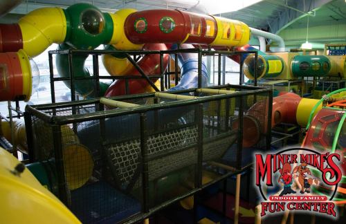 Colorful indoor play structure with tunnels and slides at Miner Mike's Fun Center.