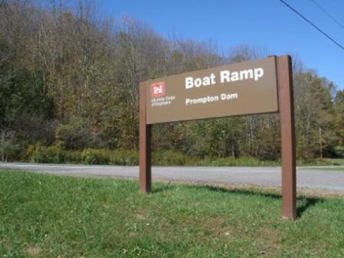 Sign for "Boat Ramp" at Prompton Dam, with trees in the background and a grassy area in the foreground.