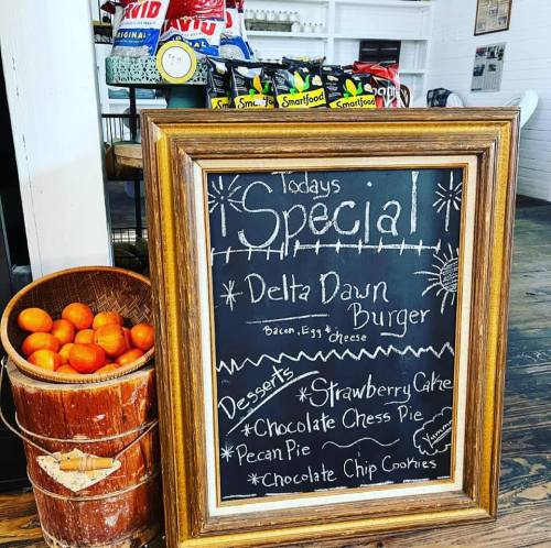 Chalkboard sign listing today's special: Delta Dawn Burger, with desserts including strawberry cake and various pies.