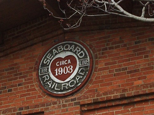 Sign on a brick wall featuring "Seaboard Railroad" and "Circa 1903" in a circular design.