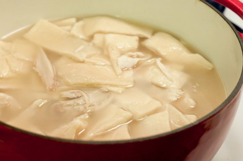 A pot filled with pieces of meat submerged in a light broth.