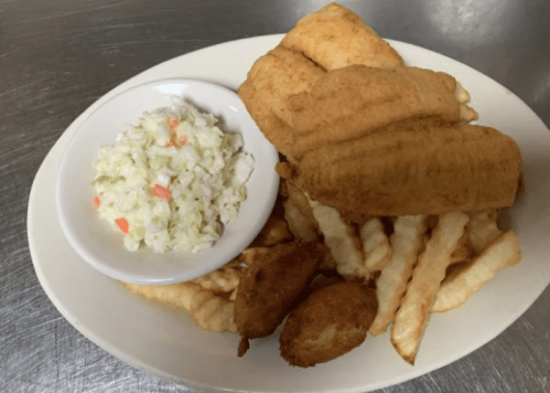 A plate of fried fish fillets, crinkle-cut fries, and a side of coleslaw.