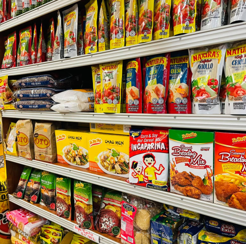 A colorful display of various food products on shelves, including sauces, noodles, and breading mixes.