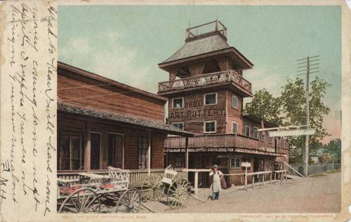 Historic postcard of the Bloux Pottery building in Bloom, Mississippi, featuring a multi-story structure and vintage carriages.